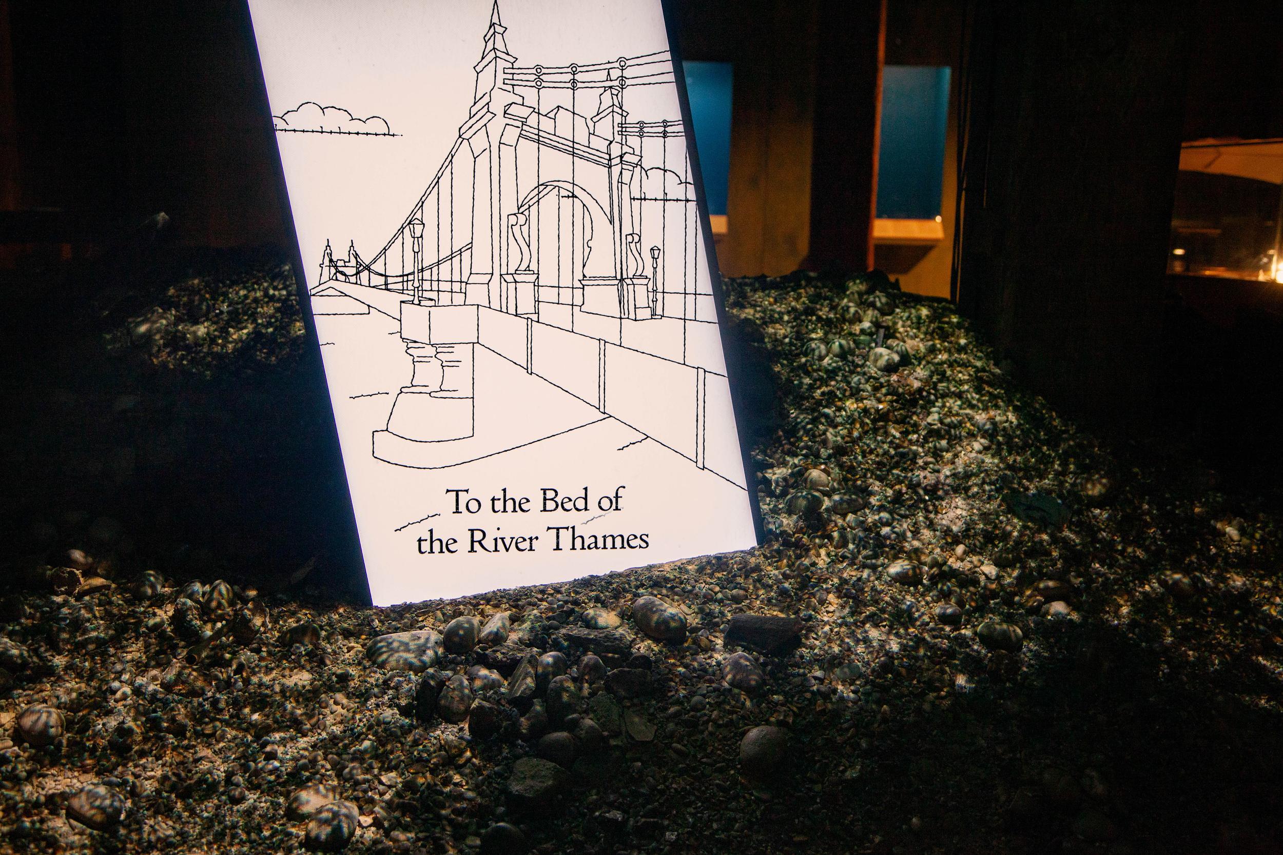 A photo of an LCD screen embedded in the setworks at an angle. On the screen is a atill from the animation showing an illustration of Hammersmith Bridge and the words 